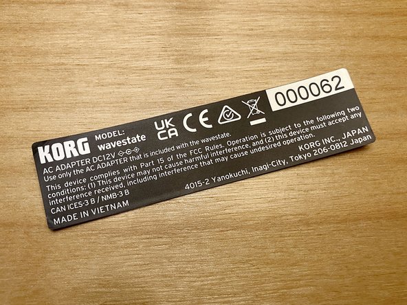 Use a pair of scissors to carefully trim the double-sided tape around the edges of the serial number sticker. Alternately, you can use a sharp craft knife and a cutting mat.