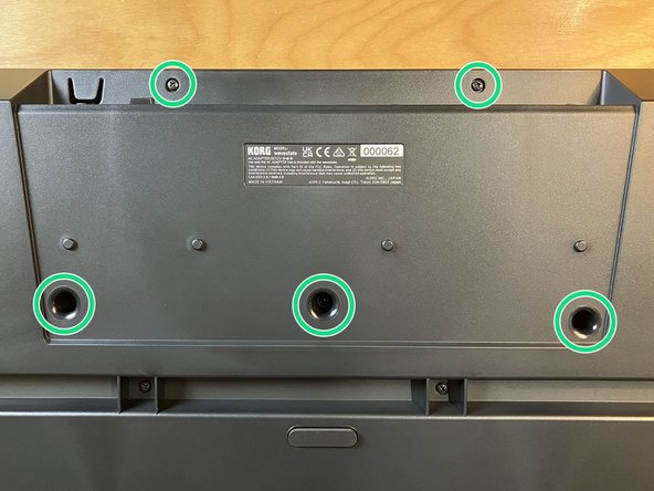 Using the #2 Phillips driver, remove the five Phillips head screws from the bottom of the device, as indicated.