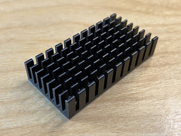 Locate the rectangular aluminum heatsink included in the parts bag.