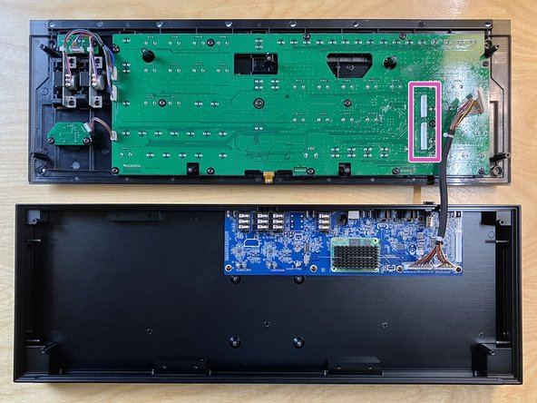 Position the front panel next to the rear of the aluminum enclosure, as shown, with its circuit board facing up and its two white connectors as close to the main board as possible.