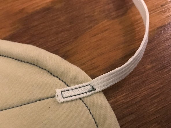 The end of the elastic should extend past the sewn border by about 1/4" (6 mm) as pictured.
