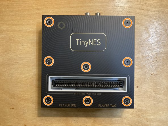 Place the TinyNES on a flat work surface. Make sure that nothing (including cables, controllers, or a cartridge) is connected to it. If the Cartridge Latch accessory is installed, please remove it first.