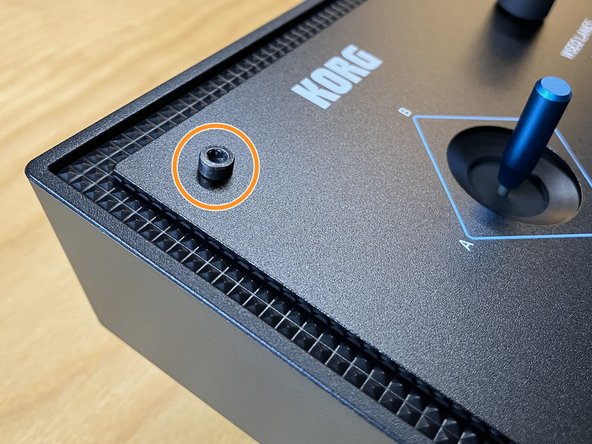 Using the 2.5 mm hex driver, remove the four socket head screws from the corners of the front panel, as indicated.