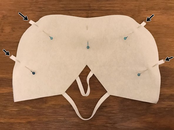 Position the strap so that it runs between one of the upper points that you just marked and the top of the V-shaped cutout.