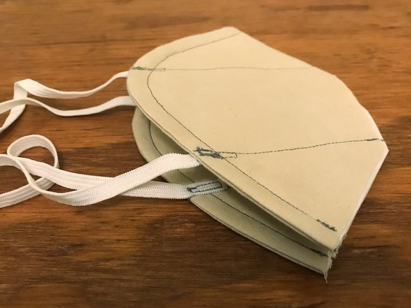 Fold the mask in half, aligning the two bottom corners with each other.