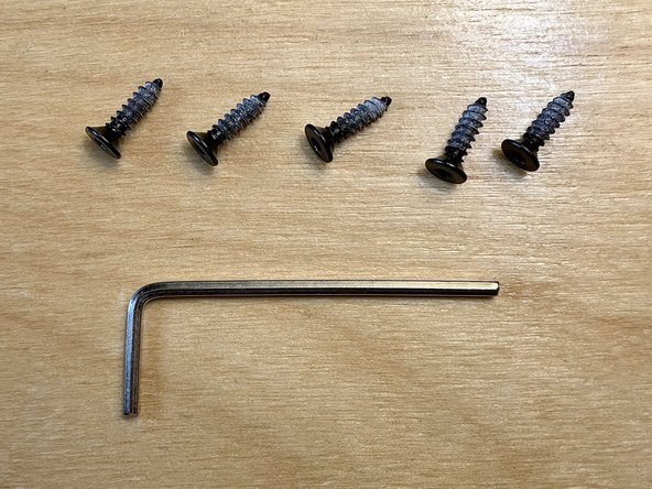 Locate the five M3 × 12 mm flat head tapping screws from the parts bag.