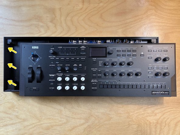 Lift and rotate the front panel to position it above the aluminum enclosure.