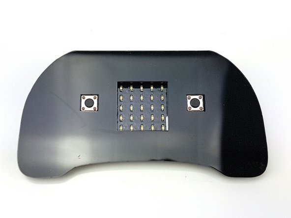 Peel the packing off of the 4 sticky squares, and stick the micro:bit onto the controller plate as shown in the picture.
