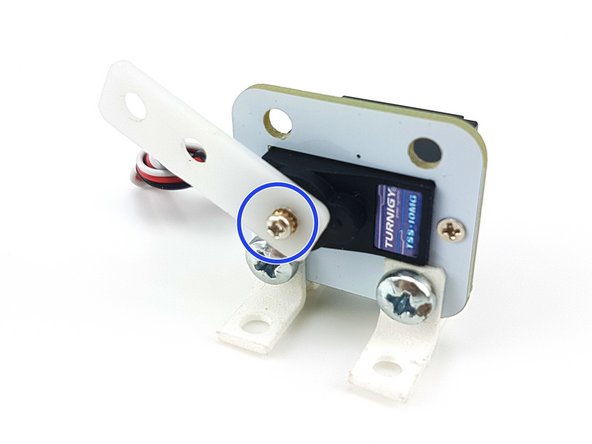 Push the large, flat piece of white plastic with 3 holes onto the servo, and use the tiny screw to hold it in place.