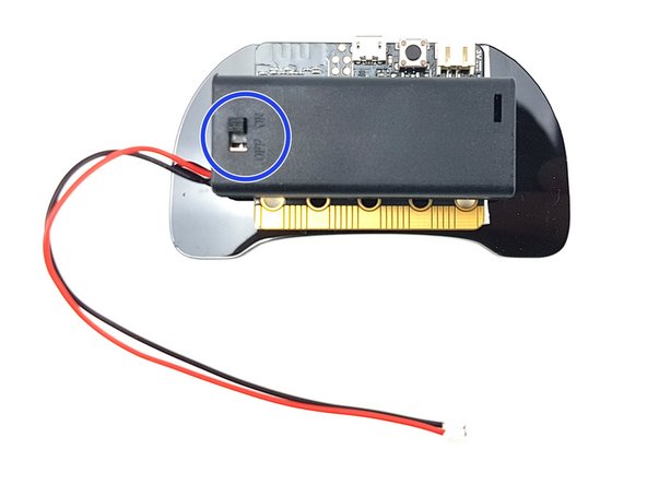 Peel of the other side of the pads and stick the battery pack onto the back of the controller like the picture - you should be able to see the switch.