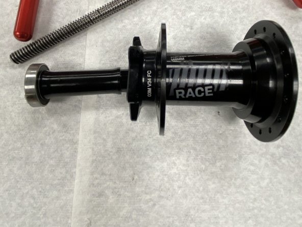 Tighten the tool handles to press the axle reducer and the disc-side bearing out of the hub shell. The axle reducer will still be attached to the bearing. The bearing can be pulled off the reducer with firm hand pressure.