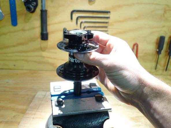 While holding the axle in the vise, install the preload adjustment ring by turning it counter-clockwise