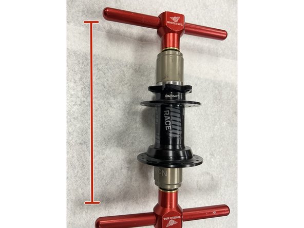 To install a new disc-side bearing, begin by gently centering the bearing in the bearing bore. Slide the bearing press drift onto the press tool and insert through the disc-side of the hub. Slide the bearing drift onto the press tool on the non disc side, and install the handle.Tighten the tool to press in the disc-side bearing.
