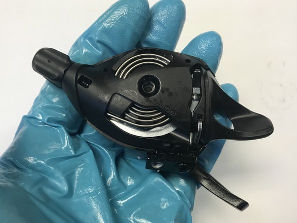 Insert the tip of the unwound portion of the spring into the notch cast into the shifter body