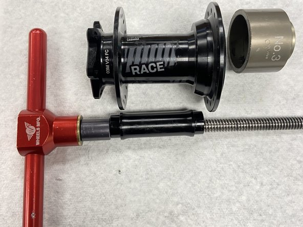 Insert the axle reducer back into the hub, and then slide the  bearing drift onto the threaded axle of the bearing press tool before inserting into the axle reducer.