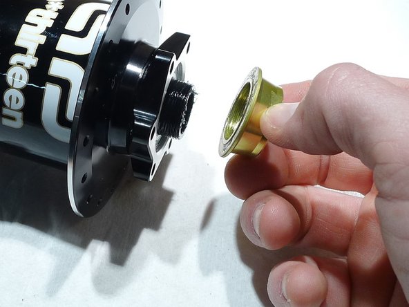 While holding the axle in the vise, install the preload adjustment ring by turning it counter-clockwise