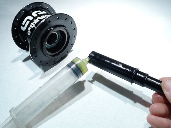 Start by lightly greasing the axle and sliding it back into the hub shell