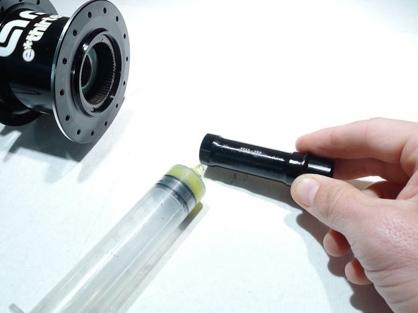 To install the axle, start by lightly greasing the reducer