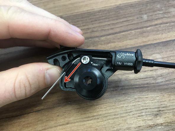 While pulling the cable tight, snug the T25 Torx until it bottoms in the hole. DO NOT EXCEED 1Nm