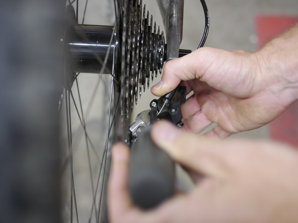 Extend the derailleur into the lowest gear (largest cog), while holding the derailleur, turn the limit screw to adjust the derailleur pulley so it is centered over the largest cog