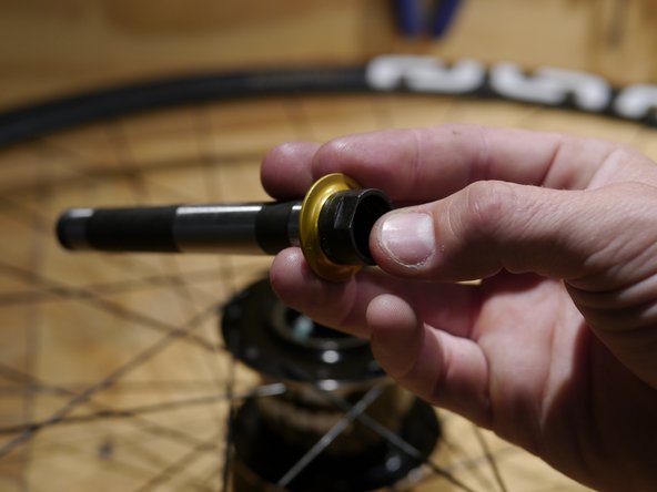 Install the spacer so the flat side is against the bearing and the tapered side is facing out from the hub