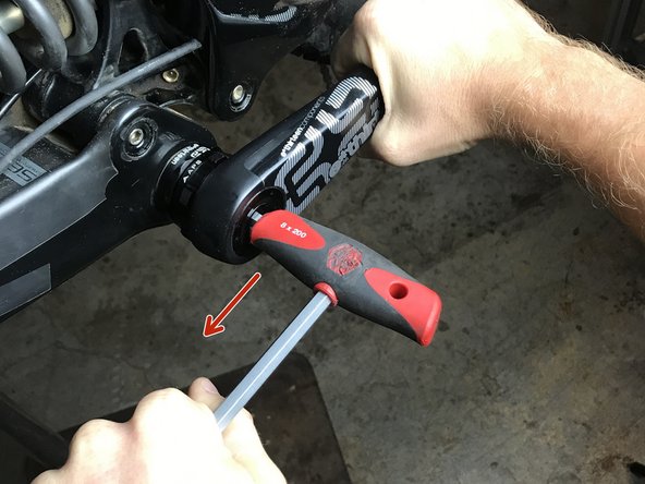 Using the 8mm allen wrench turn counter-clockwise.