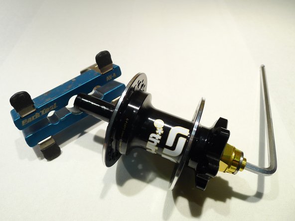 Use an axle vise or insert the flats on the drive side of the axle into a smooth jaw vise
