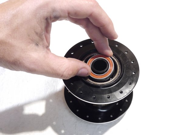 Slide the bearing spacer over the threaded rod and into the hub shell (tool removed in photo for clarity)