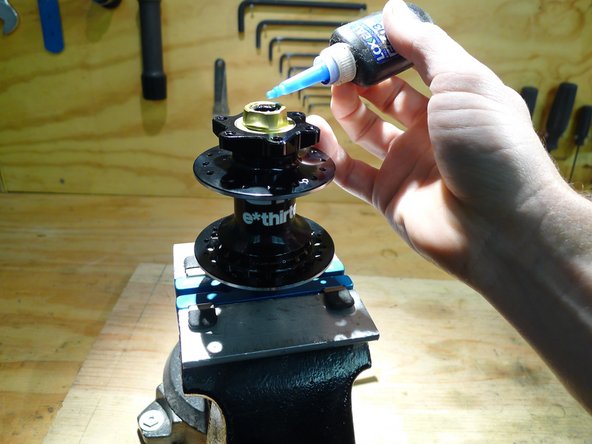 Put two drops on medium strength thread locker on the threads inside the non-drive side axle