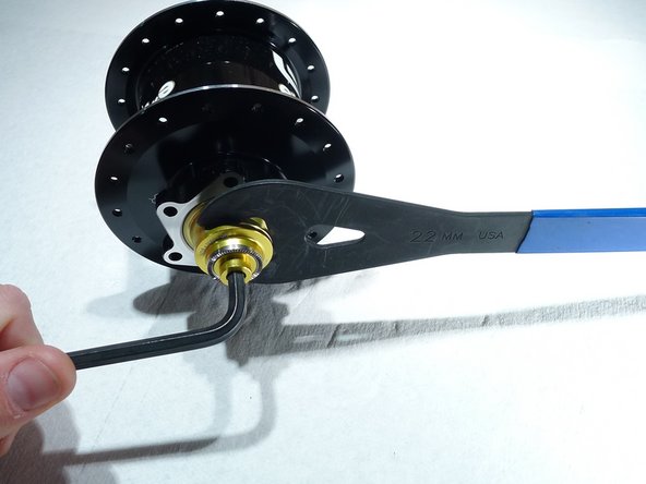 While holding the axle in the vise, loosen the non-drive endcap by turning it counter-clockwise