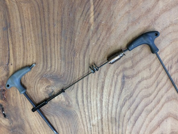 Use an M3 hex wrench and any tool that will fit into the cable slot to un-thread the cable holder from the spoke