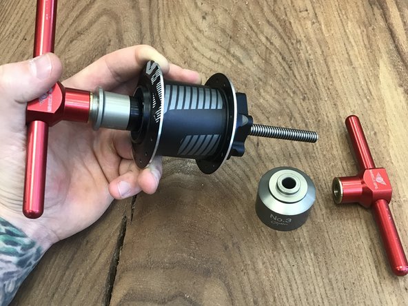 Insert threaded rod through bearing press and axle sleeve