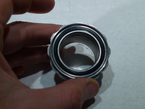 Replace the cartridge bearing seal by pressing it back into place by hand