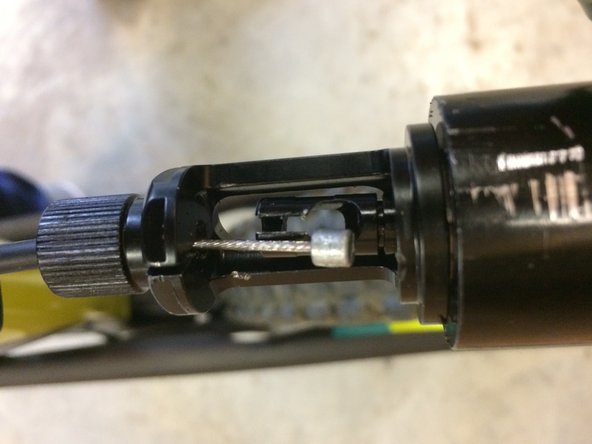 With the post slightly out of the frame, insert the cable into the post and housing