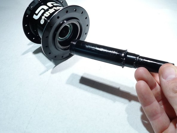 Slide the axle out of the hub shell by pushing from the non-drive side to the drive side