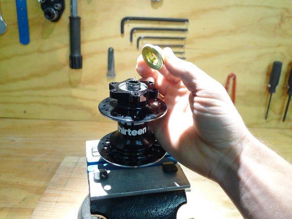 Loosen the preload ring by turning it clockwise