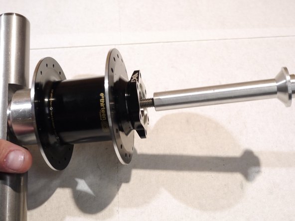 On the opposite side, place the bearing removal cup and other tool handle