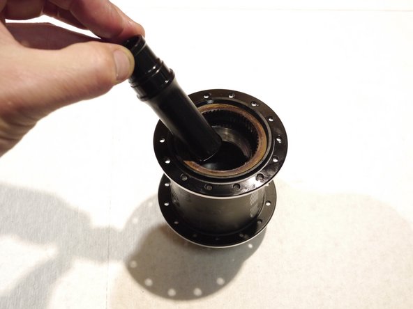 Slide the bearing spacer over the threaded rod and into the hub shell (tool removed in photo for clarity)