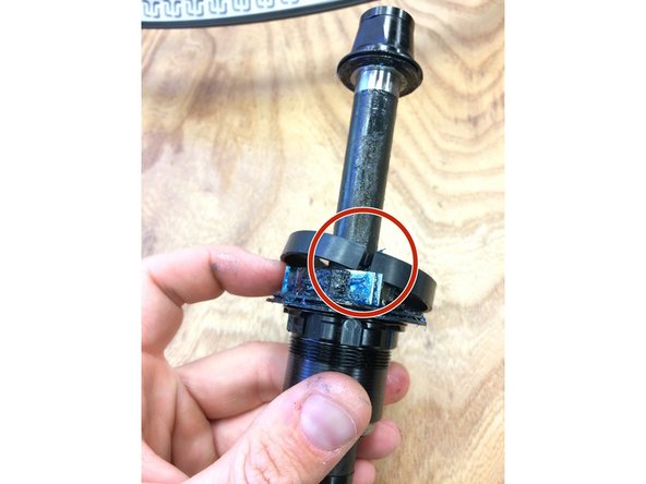 Pull the tab on the rubber ring, the ring will split at the slit and slide off the freehub body