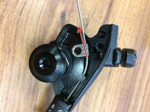 While pulling the cable tight, snug the clamp screw using a T25 Torx