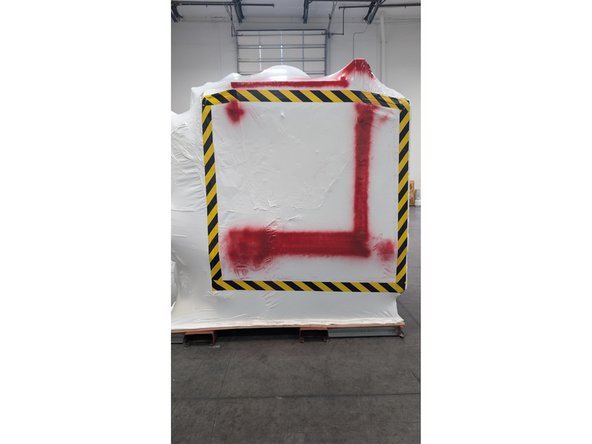 Once machine is on the pallet and wrapped, mark the side with the Auto Door with yellow and black caution tape and mark areas that could get damaged if not careful with red paint. See Photo 2
