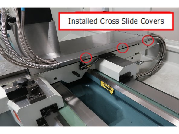 The longer of the two covers is the upper cover. It will be secured by the three screws at the edge of the lower cross slide cover as shown.
