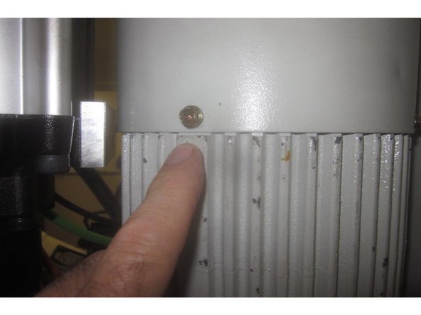 Using an 8mm wrench, remove the 4 (four) screws attaching the spindle motor fan cover to the motor.