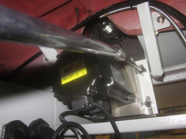 Remove the sheet metal drip pan underneath the Y-Axis motor. Remove the Y-Axis motor and belt, and set the motor aside. Do not disconnect it. Remove the motor mounting plate.