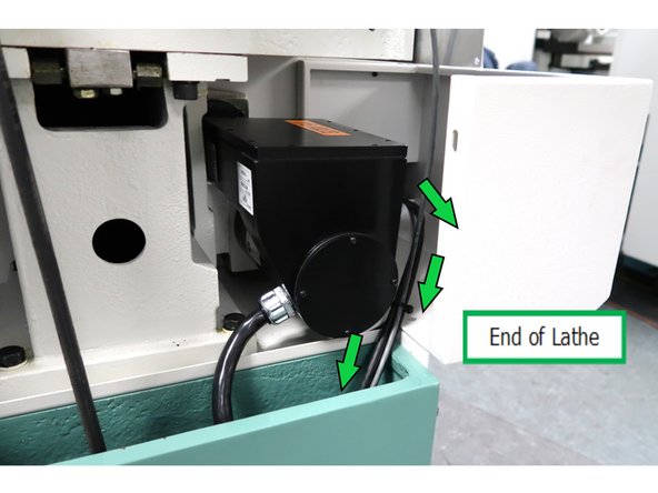 Looking from the end of the lathe, route the cable from the opening, around the motor, down in the cable channel and inside the bottom opening of the electrical cabinet.