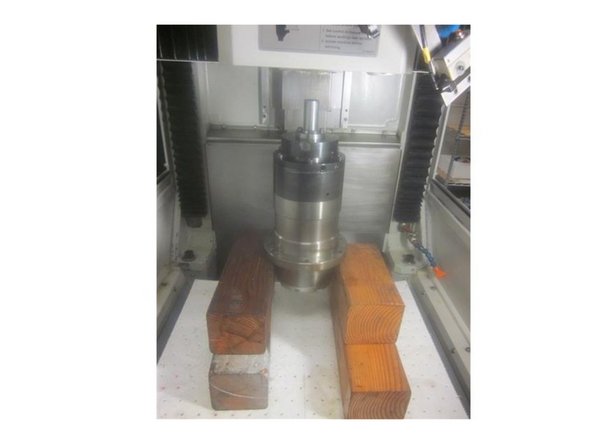 Remove the front and rear spindle bolts. The spindle will rest on the wood blocks. Slowly raise the spindle until it clears the housing. Remove the spindle.