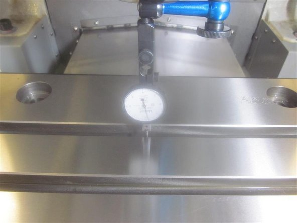 In DRO, jog the X axis left and right. The spec is .001&quot; over 10 inches.&quot; If out of spec, loosen the table mounting screws. Snug up one corner screw. Adjust the table so that the indicator reads less than .001&quot; (preferably .0005&quot; or less). Tighten up the table screws securely.