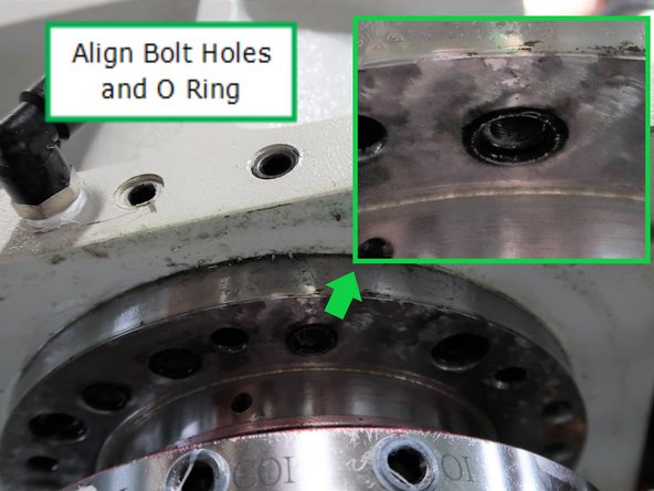Lower the casting very slowly; the holes in the spindle need to be aligned with the holes in the casting. Twist the spindle as needed. Stop the spindle flange close to the casting to test the alignment of the holes.