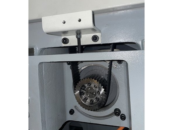 Reinstall the belt adjustment bracket and raise the motor up so the belts can be installed.