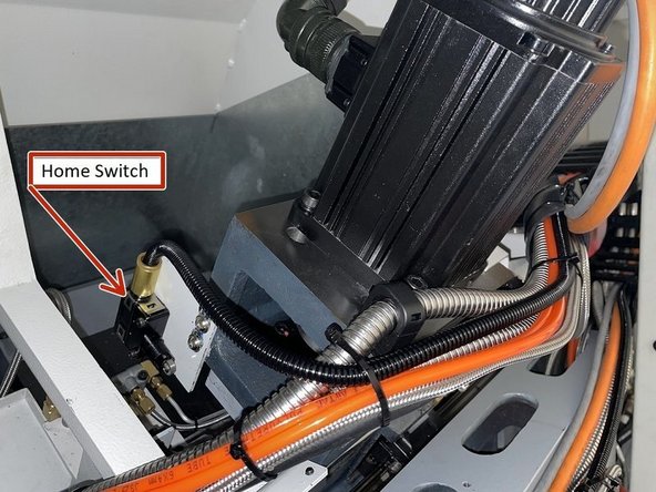 The home switch is mounted on the left side of the X motor casting when viewed from the rear of the machine.